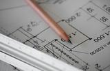 Photo of a pencil and a ruler on backdrop of a tchnical drawing